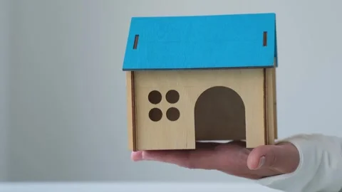 Hand shows house model on gray background. Mortgage, investment, real estate Stock Footage 256684862