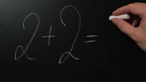 A hand shows a math equation on a chalkboard while correcting an addition Stock Footage 338186536