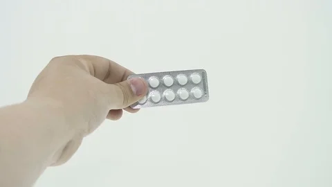 Hand shows the packaging of white pills Stock Footage 106677146