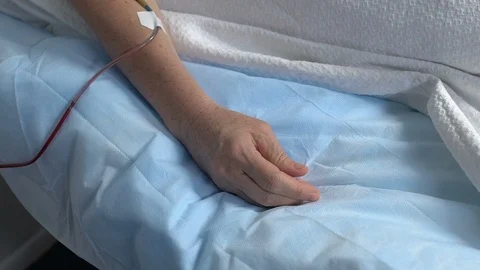 Hand of sick senior patient squeezing bed sheet in hospital, suffering pain 動画素材 117172142