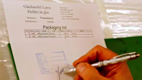 Hand signing packaging list document with pen in warehouse setting closeup Stock Footage 334671515