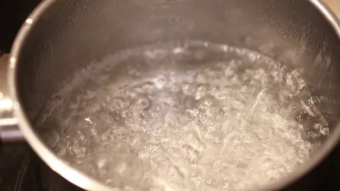 Hand sinking pasta into boiling water Видео 81268029