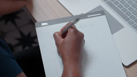 Hand Sketching Notes Beside Laptop in Office Stock Footage 327359532