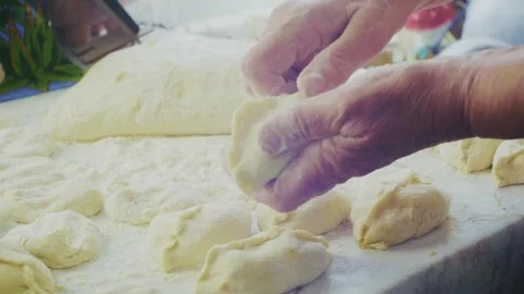 The hand skillfully forms the dough on the floured surface Stock Footage 313270335
