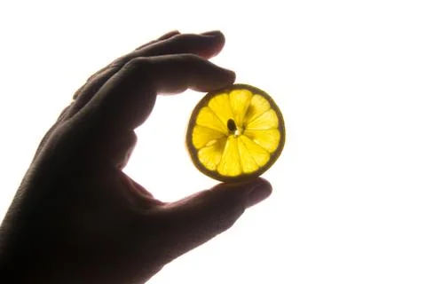 Hand with slice of yellow lemon Stock Photos