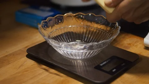 Hand slices butter into dish on scale to measure weight, close-up Stock Footage 123807792