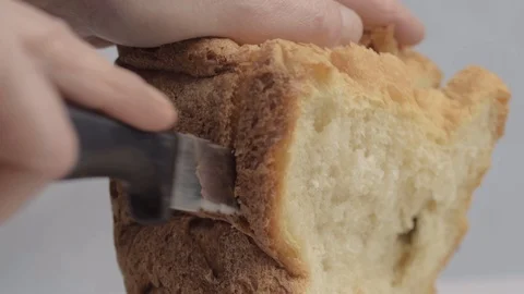 Hand slicing fresh loaf of bread close up side shot Stock Footage 129355169