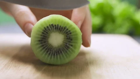 Hand slicing a kiwi with a knife Video stock 101370664