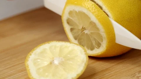 Hand Slicing Lemon on Cutting Board Stock Footage 125397267