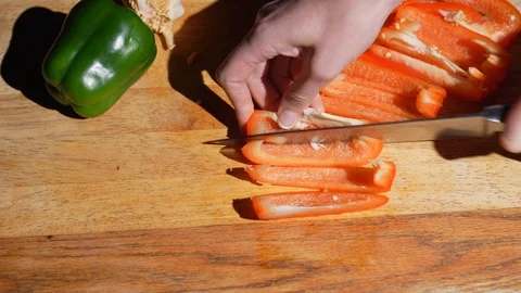Hand slicing red bell pepper in slivers Stock Footage 125568622