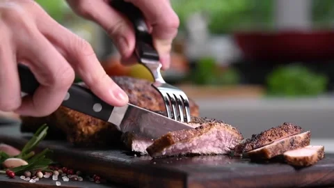 Hand slicing roast beef on a cutting board in the kitchen Stock Footage 154600861