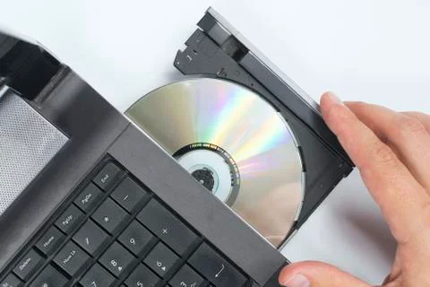 A hand that slides a compact disc inserted into the drawer of the SD drive of Stockfoto's
