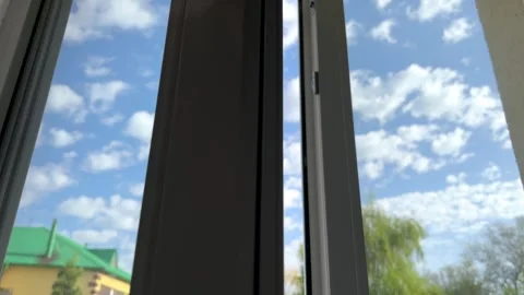 Hand is slowly reaching out to open and reveal window as sun shines through Stock Footage 274782286