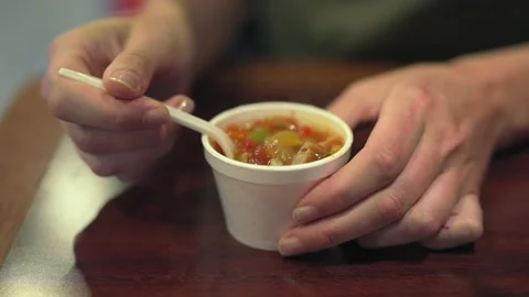 Hand slowly stirs sample cup soup Stock Footage 159997625