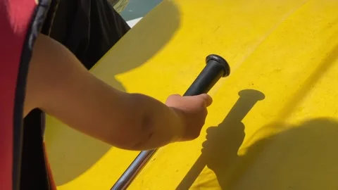 The hand of a small child in a red life jacket controls the catamaran. Stock Footage 247186338