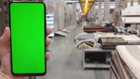 In hand a smartphone with a green screen in the background of the carpet and Stock Footage 282513934