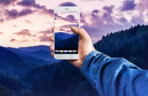 Hand with smartphone using photo application in forest mountains. Stock Photos