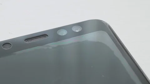 Hand smoothes out bubbles after putting new safety screen on smartphone. Stock Footage 129782010