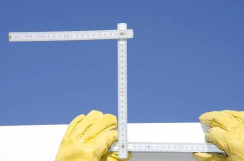 Hand sof builder with ruler and blue sky background Stock Photos