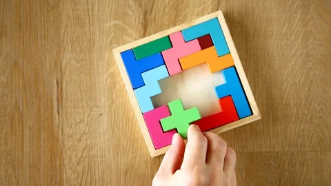 Hand solving a puzzle of wooden block Stock Footage 129643312