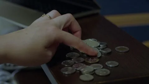 Hand sorting coins on table for personal budgeting 库存影片 341767369