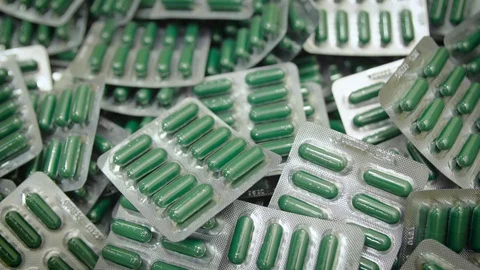 A hand sorting out green capsule pills in blister pack Stock Footage 102465581