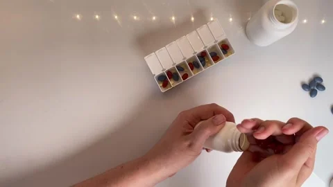 Hand sorting pills into daily container on white table, pills arrangement s.. Stock Footage 320956658