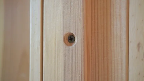 Hand spackling a round countersunk hole with screw head Stock Footage 87900874