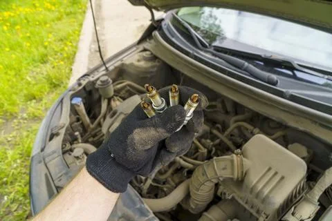 Hand with spark plugs while checking ignition system and replacing spark plugs Foto stock