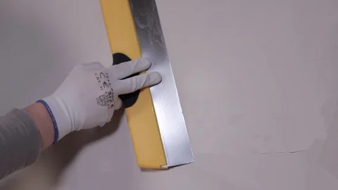 Hand with spatula Applies Plaster To The Wall Stock Footage 101382947