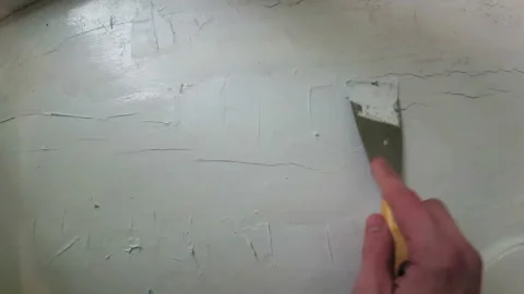Hand with spatula is applying putty on windowsill Stock Footage 94864649