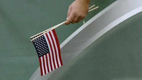 Hand of spectator holding two small American flags in stadium Stock Footage 104772886