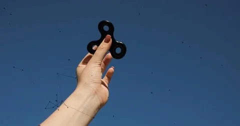 Hand spinner, or fidgeting spinner, rotating in hand with animation Stock Footage 76735384