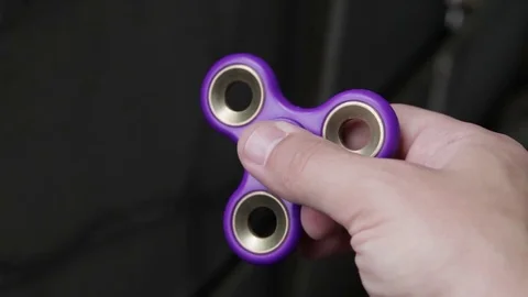 Hand spinner or fidgeting spinner rotating on child's hand Stock Footage 77158392