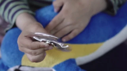 Hand spinner or fidgeting spinner rotating on child's hand (Only the hands) Stock Footage 77279244