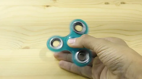 Hand spinner, or fidgeting spinner, rotating on child's hand Stock Footage 80181085