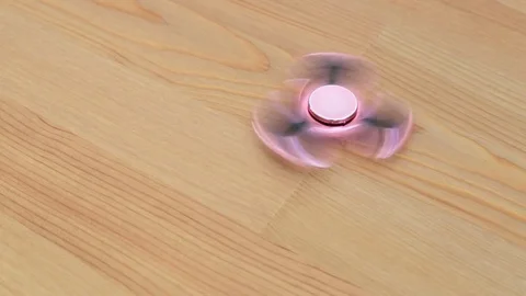 Hand spinner on table Video stock 77213824