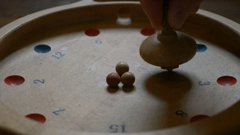 Hand spinning a spinning top of an old game Stock Footage 87729952