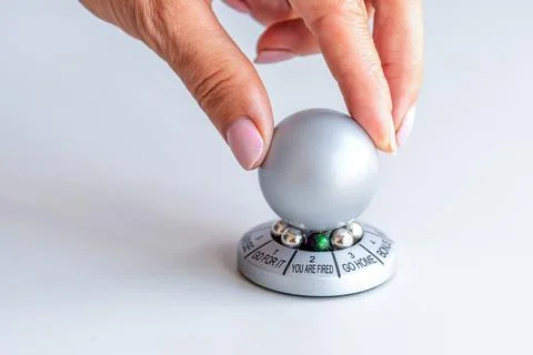 Hand spinning the wheel of opportunity, pointer on YOU ARE FIRED, concept of  库存照片