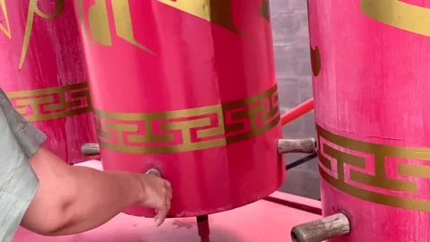 Hand spins a prayer wheel with a buddhist temple Stock Footage 201751828