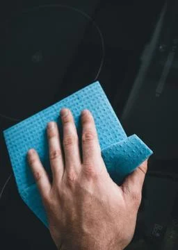Hand with a sponge cleaning surface in kitchen Stock Photos