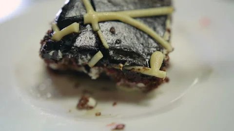 Hand with a spoon breaks off a piece of chocolate cake on a plate 库存影片 87021584