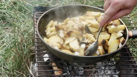 Hand with a spoon mix potatoes with onions, fried in a frying pan on a grill Vídeos de archivo 205872825