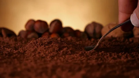 Hand with spoon pushing through cocoa powder lifting up a dose Video stock 102298976