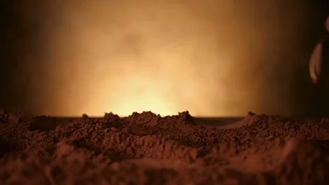 Hand with spoon pushing through cocoa powder - static camera Video stock 104464167