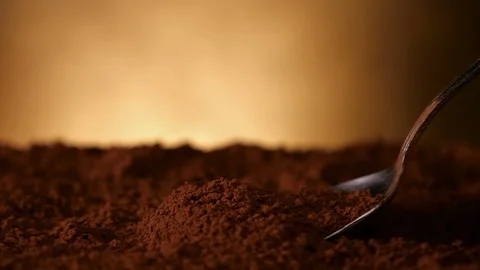 Hand with spoon pushing through cocoa powder - close up, slow motion Video stock 104464174