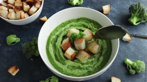 Hand with spoon take broccoli puree soup with croutons first person view Stock-Footage 119422796