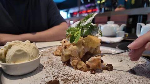 A hand with a spoon taking a piece of apple dessert. Stock Footage 317675660