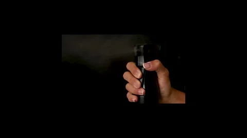 Hand Spraying Fine Mist from Black Spray Bottle on Dark Background Stock Footage 344208248