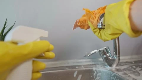 Hand spraying rust and stain remover on metal items, cleaning sink with eco-frie Stock Footage 301869170